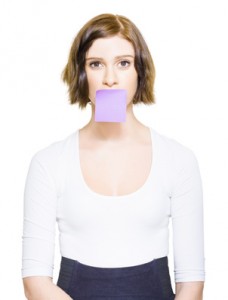 woman with blank post-it note over mouth