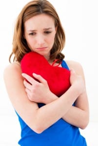 Sad woman holding heart