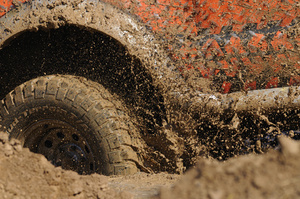 car spinning wheels in mud