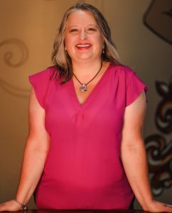 Christina Ammerman standing with her palms flat on a table and elbows locked straight against her sides