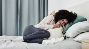 sick woman curled up in bed