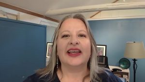 Screenshot of Christina standing with her office behind her