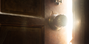 wooden door ajar with light coming from the other side