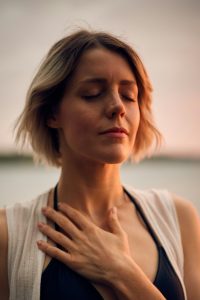 woman with eyes closed, hand over heart