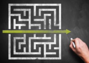 a maze drawn on a chalkboard with an arrow highlighting a path straight across it