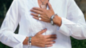 closeup of women placing her hands on her heart and bellly