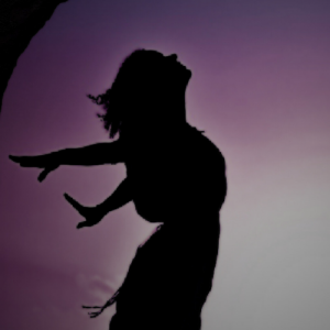 woman silhouetted against purple sky