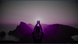 woman facing away from camera, silhouetted, raising hands together to meet the sun