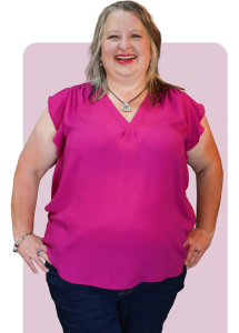 Christina wearing pink blouse, standing with hands on hips