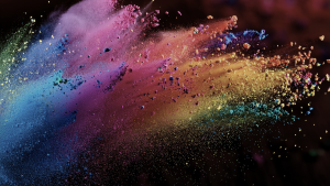 multi-colored explosion of powdered paint on a dark background